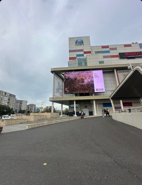 Large outdoor screen on a building in Bucharest showing a work by Helio Santos